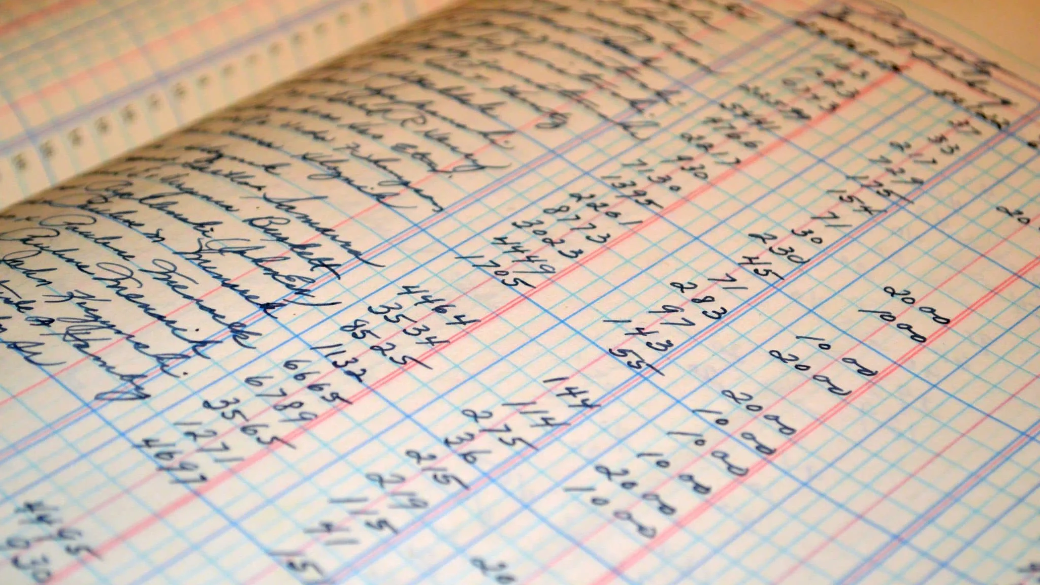 A close photograph of a handwritten accounting ledger filled with customer names and amounts, representing the paper records used before AS-HAL